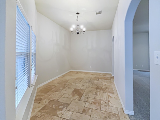 unfurnished dining area featuring light carpet and an inviting chandelier