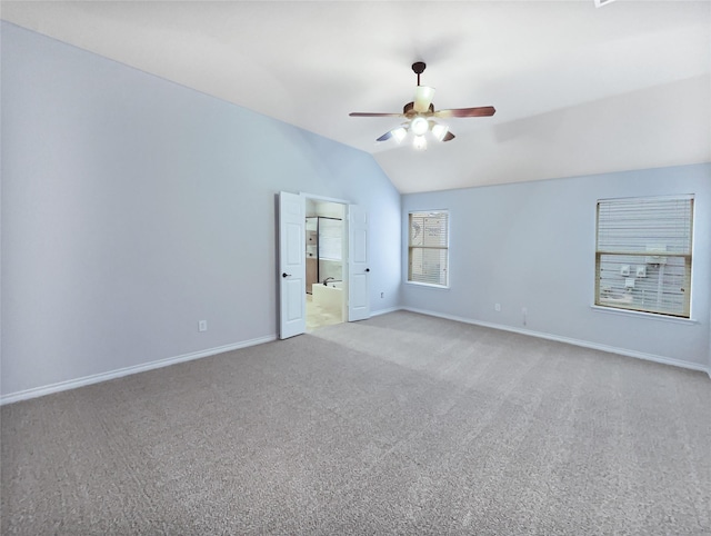 carpeted spare room with ceiling fan and vaulted ceiling