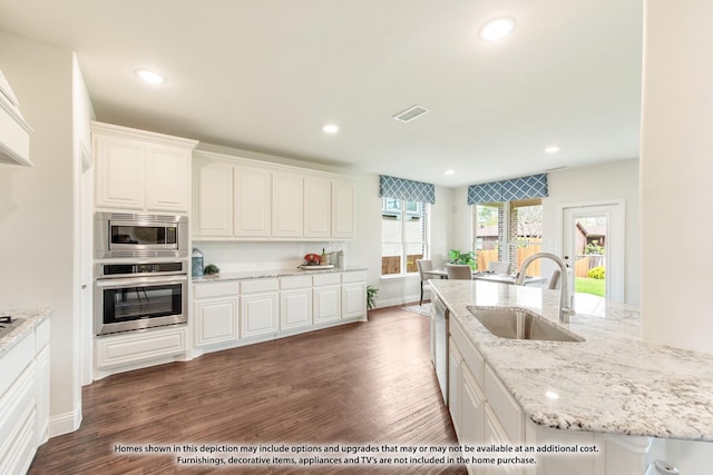 kitchen featuring dark hardwood / wood-style flooring, white cabinets, and stainless steel appliances