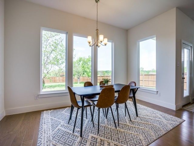 dining space featuring dark hardwood / wood-style floors, an inviting chandelier, and plenty of natural light