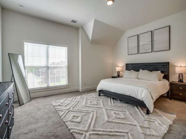 bedroom featuring light colored carpet and vaulted ceiling