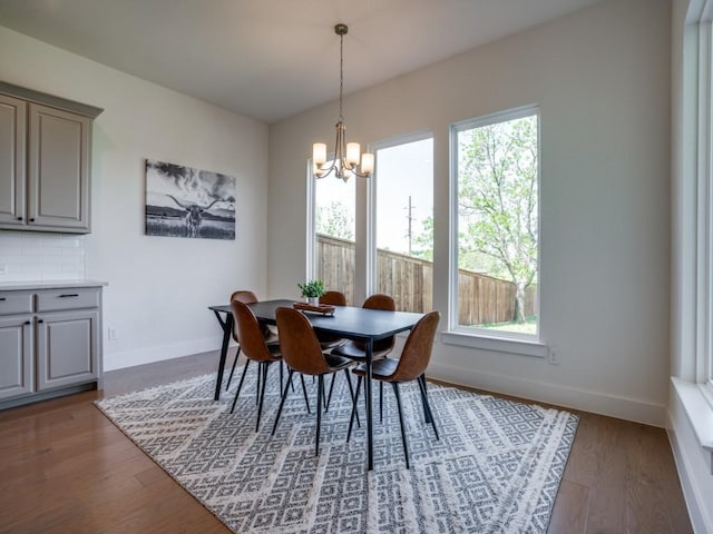 dining area featuring dark hardwood / wood-style flooring, an inviting chandelier, and a wealth of natural light