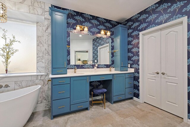 bathroom with vanity, a wealth of natural light, a tub, and tile walls