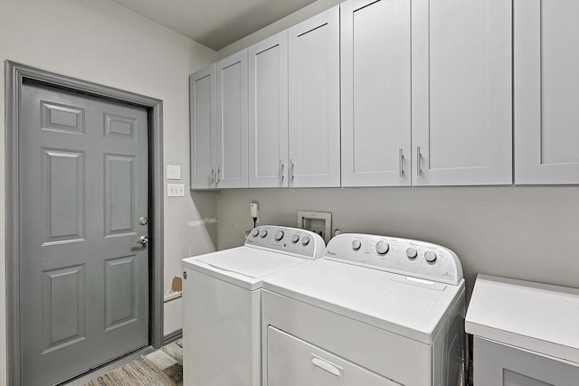 clothes washing area with cabinets and separate washer and dryer