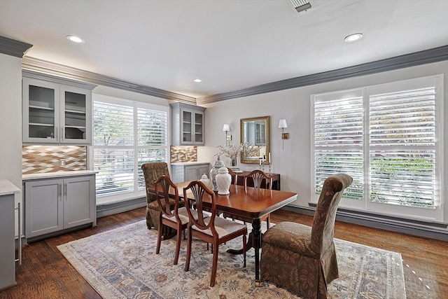 dining space with ornamental molding and dark hardwood / wood-style floors