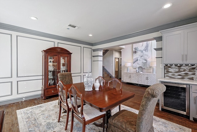 dining area featuring wine cooler, dark hardwood / wood-style flooring, and ornate columns