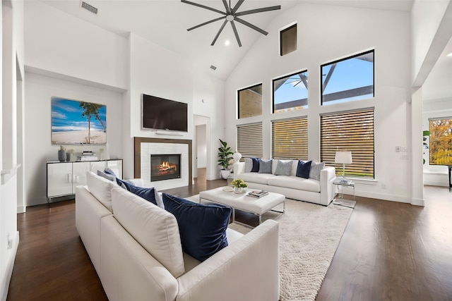 living room with a fireplace, a wealth of natural light, dark hardwood / wood-style flooring, and high vaulted ceiling