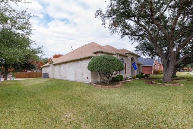 view of side of home with a lawn and central AC