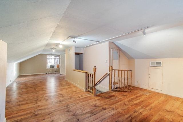 bonus room with cooling unit, wood finished floors, visible vents, baseboards, and vaulted ceiling