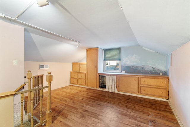 bonus room with lofted ceiling, wood finished floors, visible vents, and baseboards