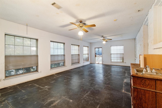 living area featuring visible vents, a textured ceiling, and concrete flooring