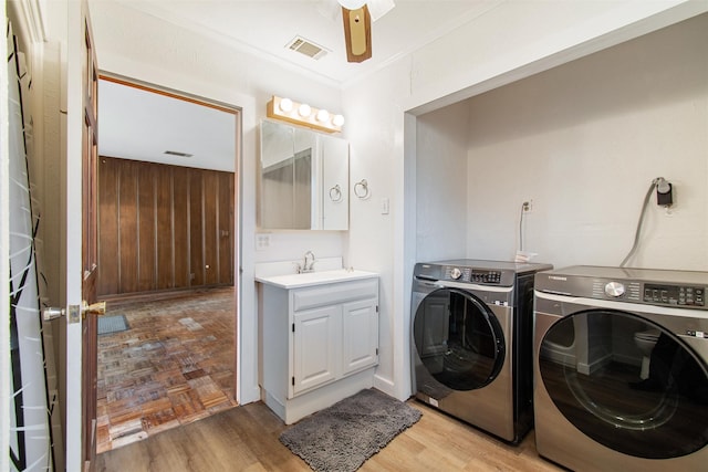 washroom featuring separate washer and dryer, ceiling fan, sink, and light parquet floors