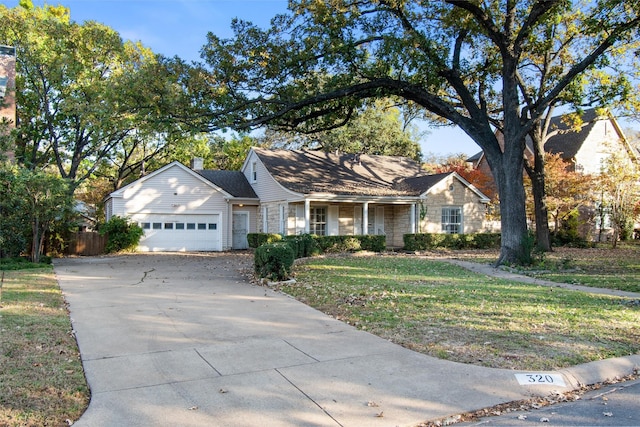 ranch-style home featuring a front yard, concrete driveway, and an attached garage