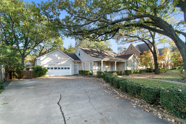 view of front facade with an attached garage, fence, and driveway