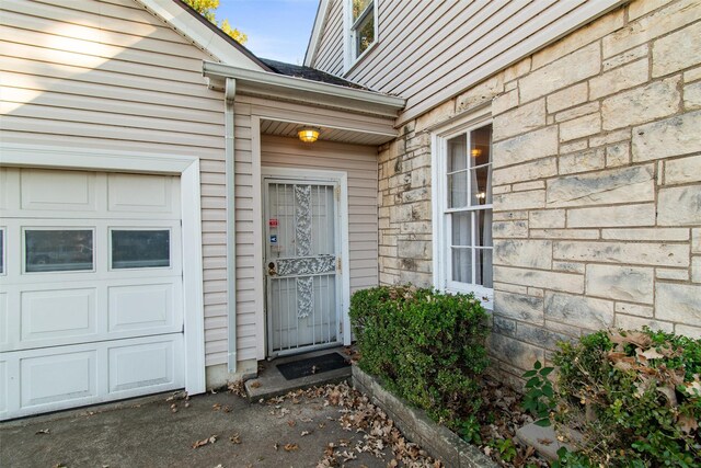 property entrance featuring stone siding and an attached garage