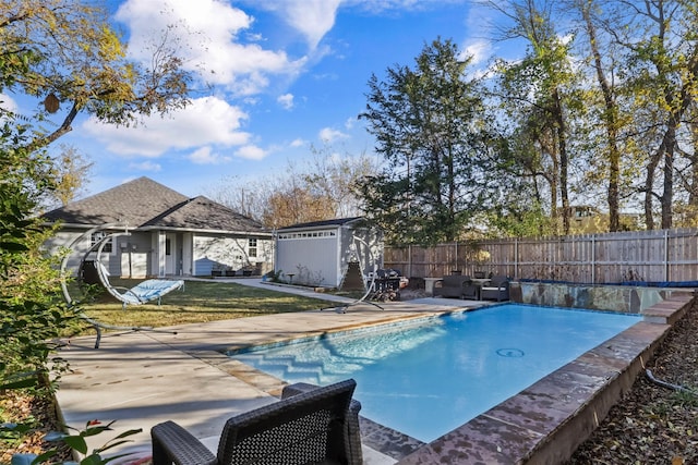 view of swimming pool featuring a lawn, an outdoor structure, and a patio