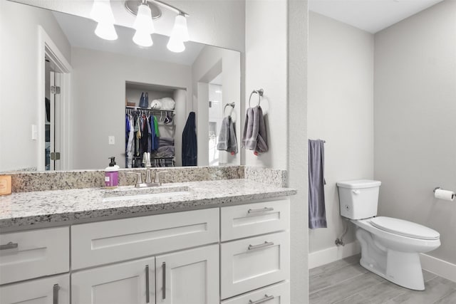 bathroom featuring vanity, hardwood / wood-style floors, and toilet