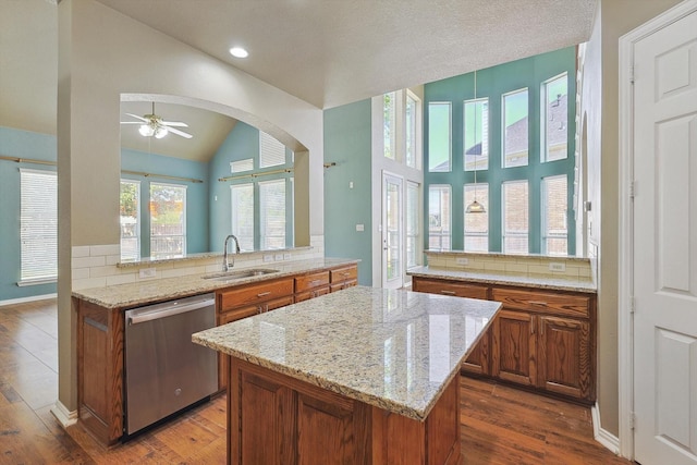 kitchen featuring dishwasher, dark hardwood / wood-style flooring, kitchen peninsula, and sink