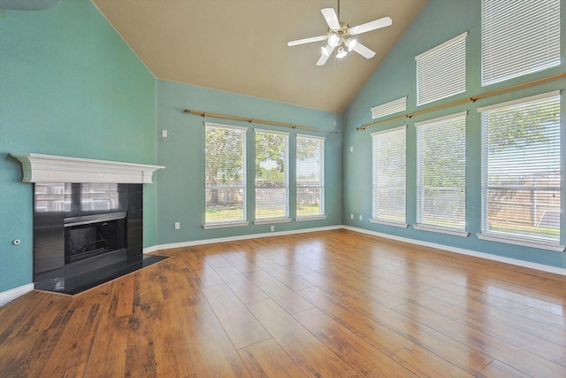 unfurnished living room with wood-type flooring, high vaulted ceiling, and a healthy amount of sunlight