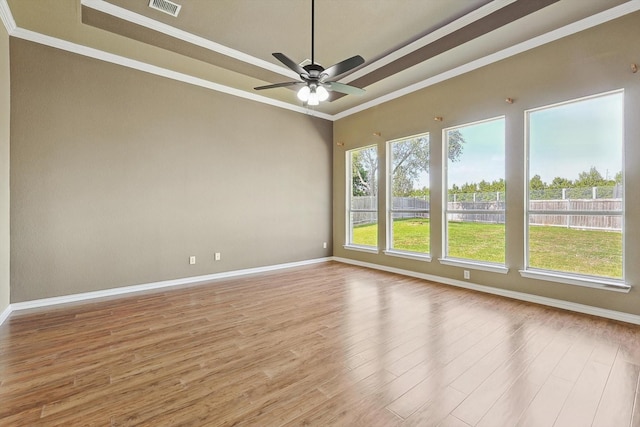 spare room featuring ceiling fan, light hardwood / wood-style floors, a raised ceiling, and ornamental molding