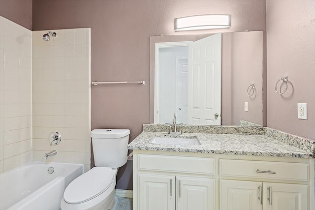 full bathroom with tiled shower / bath, vanity, and toilet