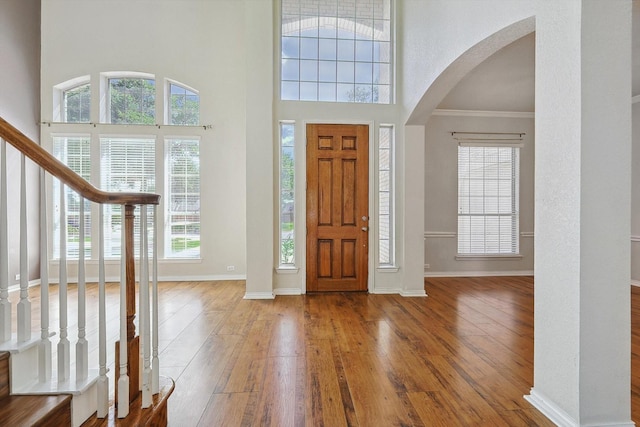 foyer entrance with hardwood / wood-style floors and a high ceiling