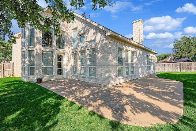 rear view of property with a patio area and a yard