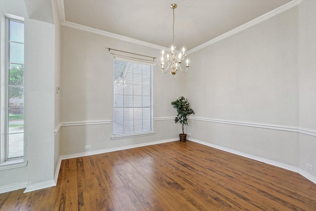 empty room with hardwood / wood-style floors, a notable chandelier, and ornamental molding