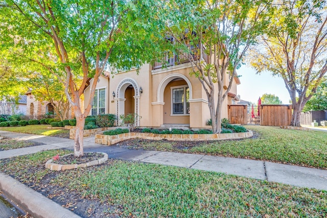 mediterranean / spanish-style home with a balcony and a front lawn