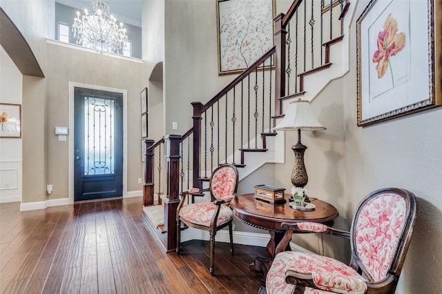 entrance foyer featuring dark hardwood / wood-style flooring, a high ceiling, and an inviting chandelier