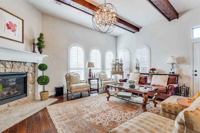 living room with beam ceiling, a wealth of natural light, a fireplace, and hardwood / wood-style flooring