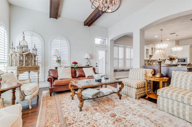 living room with beam ceiling, dark wood-type flooring, and a notable chandelier