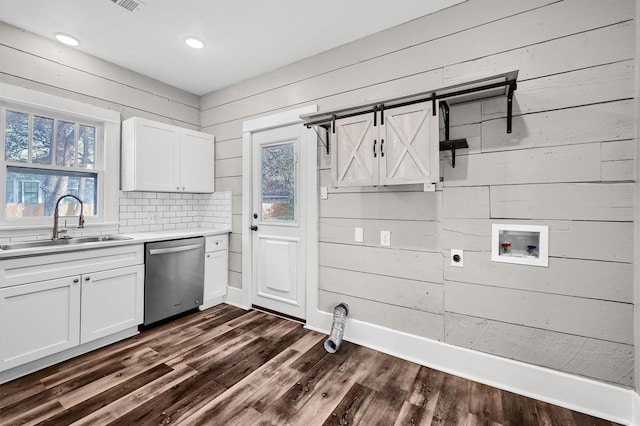 laundry area with washer hookup, dark hardwood / wood-style floors, wood walls, and sink