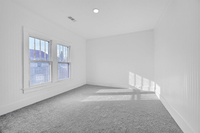 carpeted empty room featuring crown molding