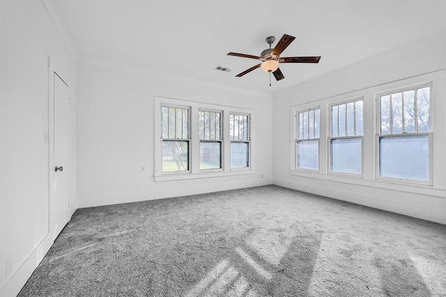 spare room featuring crown molding, plenty of natural light, carpet, and ceiling fan