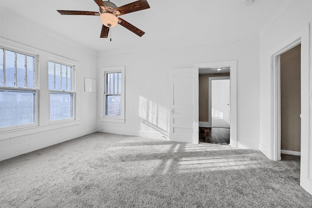 unfurnished living room with crown molding, carpet, and ceiling fan