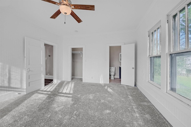 unfurnished bedroom with carpet floors, ceiling fan, and connected bathroom