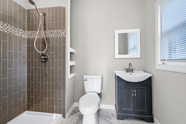 bathroom featuring vanity, toilet, and tiled shower