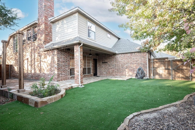 back of house with a patio area and a lawn