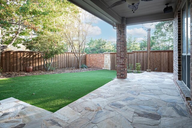 view of yard featuring ceiling fan and a patio