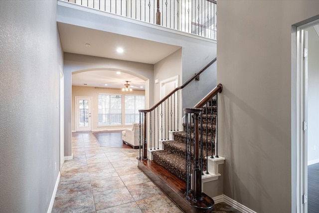 entrance foyer featuring ceiling fan and a towering ceiling