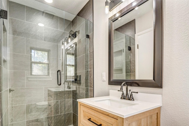 bathroom with vanity and a shower with door