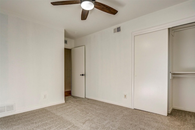 unfurnished bedroom with ceiling fan, light carpet, and a closet