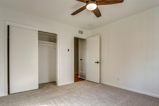 unfurnished bedroom featuring ceiling fan, light carpet, and a closet