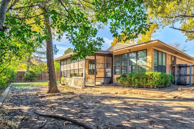 view of property exterior with a sunroom