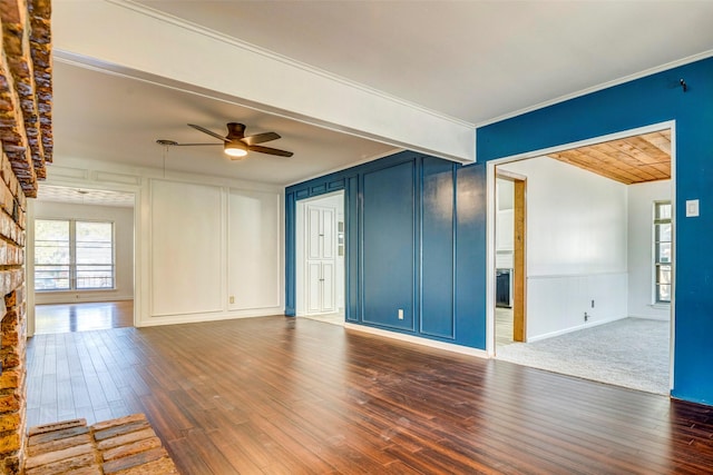 unfurnished living room featuring dark hardwood / wood-style floors, ceiling fan, crown molding, and a fireplace