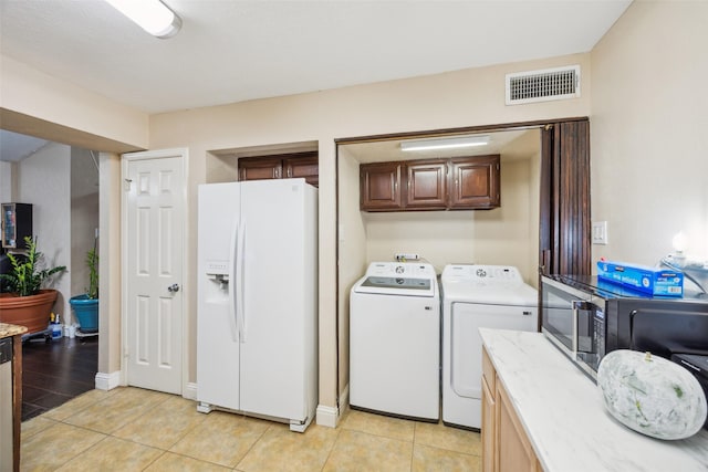 washroom with cabinets, light hardwood / wood-style flooring, and washing machine and clothes dryer