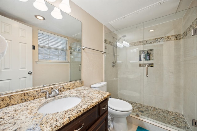 bathroom featuring tile patterned floors, toilet, vanity, and walk in shower