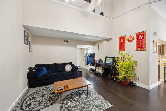 living room with dark wood-type flooring and a high ceiling