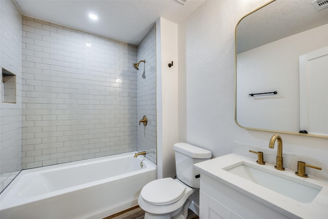 full bathroom featuring vanity, tiled shower / bath combo, a textured ceiling, and toilet